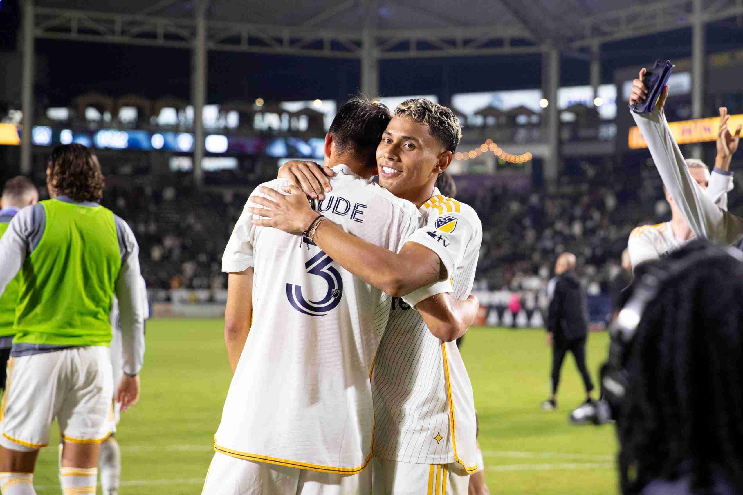 Oct 26, 2024; Carson, California, USA; LA Galaxy defender Julian Aude (3) and midfielder Edwin Cerrillo (20) celebrate their win against the Colorado Rapids during postgame at Dignity Health Sports Park. Mandatory Credit: Bailey Holiver-Imagn Images