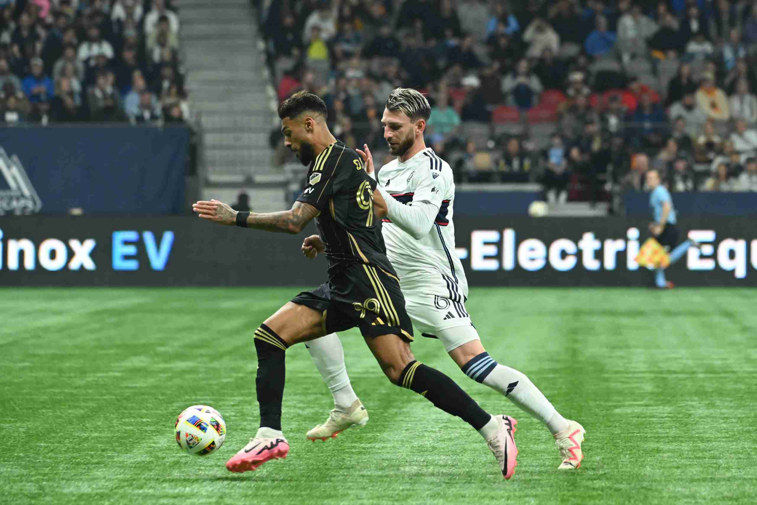 Nov 3, 2024; Vancouver, British Columbia, CAN; LAFC forward Denis Bouanga (99) plays the ball defended by Vancouver Whitecaps defender Tristan Blackmon (6)in the second half in a 2024 MLS Cup Playoffs Round One match at BC Place. Mandatory Credit: Simon Fearn-Imagn Images