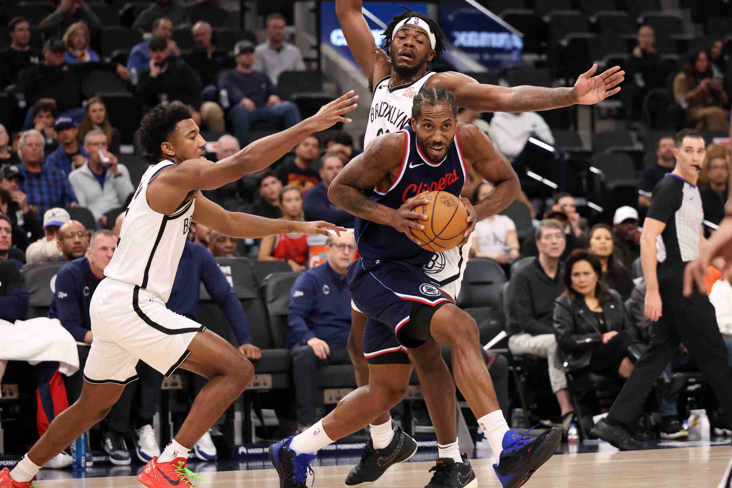 Jan 15, 2025; Inglewood, California, USA; LA Clippers forward Kawhi Leonard (2) drives between Brooklyn Nets guard Reece Beekman (4) and center Day'Ron Sharpe (20) during the first half at Intuit Dome. Mandatory Credit: Kiyoshi Mio-Imagn Images
